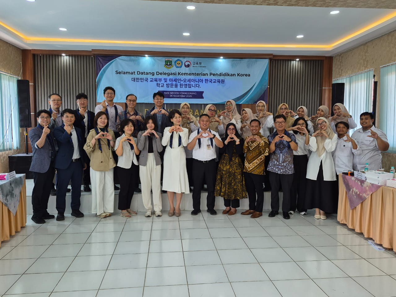 Foto grup pelajar pertukaran di depan spanduk acara Korea Selatan