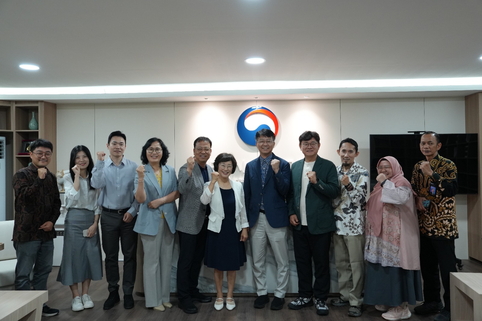 Foto grup pelajar pertukaran di depan spanduk acara Korea Selatan